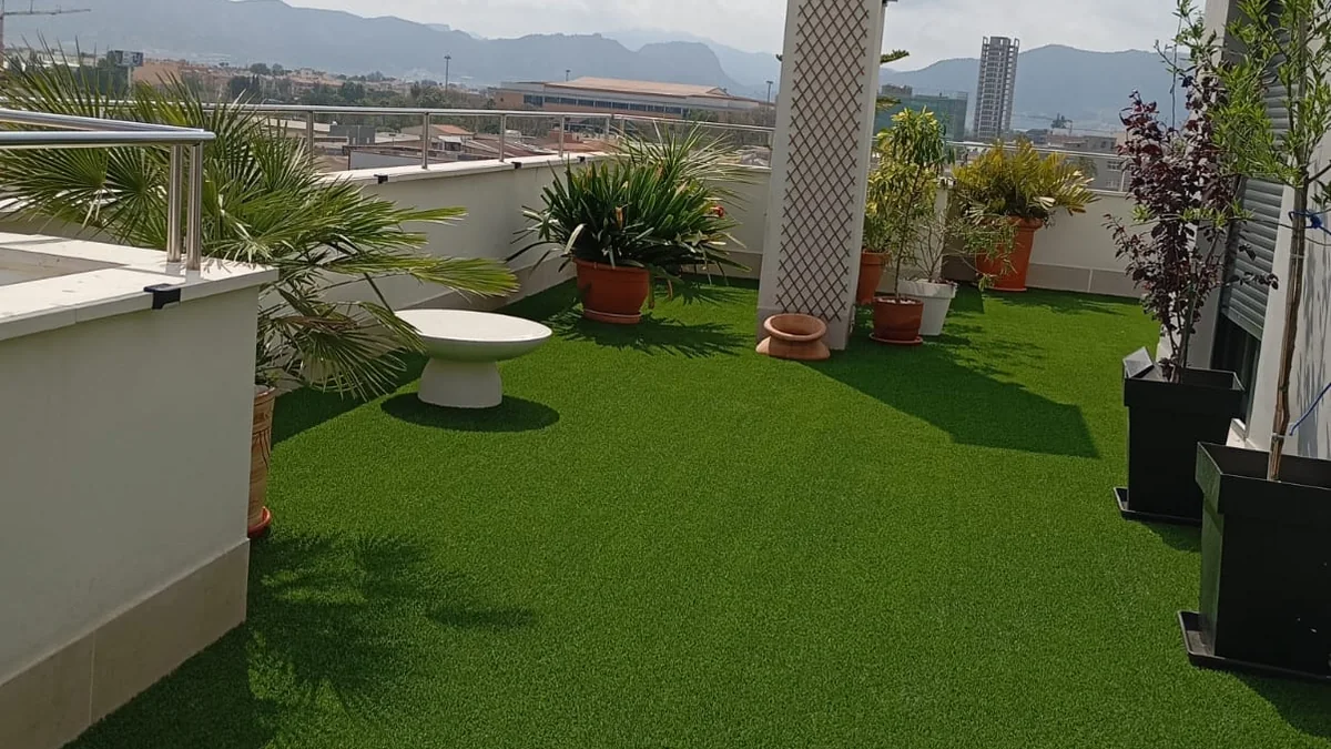 Césped artificial en ático, terraza con chimenea y vistas a montaña