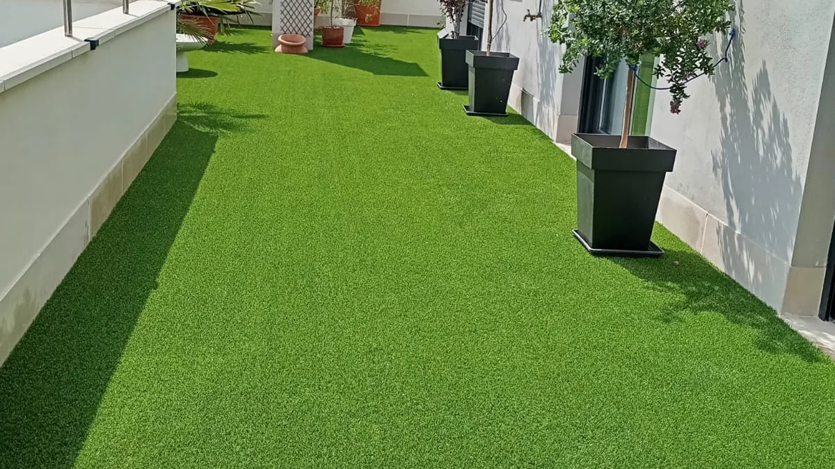 Césped artificial en ático, terraza con macetas y vistas